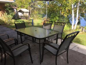 - une table et des chaises noires sur la terrasse dans l'établissement Gite du Lac Docteur, à Saint-Honoré