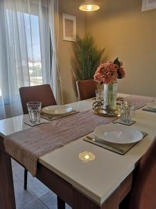 een eettafel met een vaas met bloemen erop bij Spacious 2 Bedroom Apartment in Accra