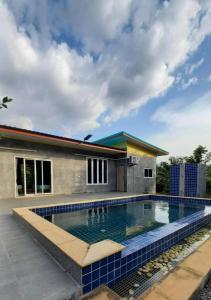 a swimming pool in front of a house at Pool Villa Rai View Khao in Ban Klang