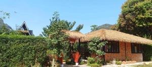 a small brick house with a straw roof at Pool Villa Rai View Khao in Ban Klang