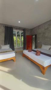 two beds sitting in a room with windows at Pool Villa Rai View Khao in Ban Klang