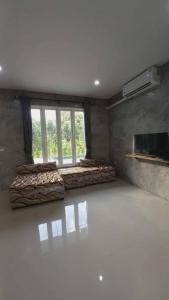 a room with a bed and a large window at Pool Villa Rai View Khao in Ban Klang