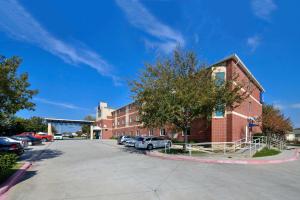 a parking lot in front of a brick building at Motel 6-McKinney, TX - North in McKinney