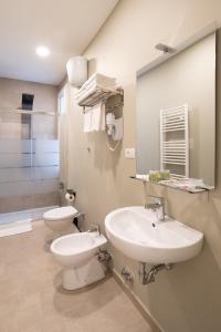 a bathroom with a sink and a toilet and a mirror at Hotel Richard in Agliana +35 photos