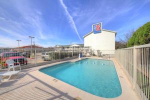 a swimming pool in front of a building at Motel 6-Kerrville, TX in Kerrville
