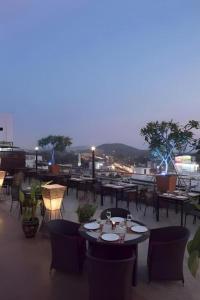 eine Gruppe von Tischen und Stühlen auf einem Dach in der Unterkunft Bonito Chinos Hotel in Nakhon Sawan