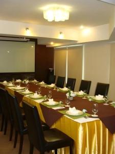 ein großer Konferenzraum mit einem langen Tisch und Stühlen in der Unterkunft Bonito Chinos Hotel in Nakhon Sawan