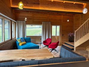 a living room with a blue couch and red chairs at Bocks Apartments 53C in Wald am Arlberg