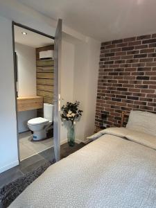 a bedroom with a bed and a toilet in a room at Le Loft Des Cigognes in Barr