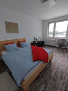 a bedroom with a large bed with a red blanket at Apartmán Emma Volary in Volary