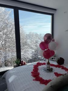 ein Zimmer mit einem Bett mit Luftballons und einem Fenster in der Unterkunft Tea House Ponoarele in Ponoarele