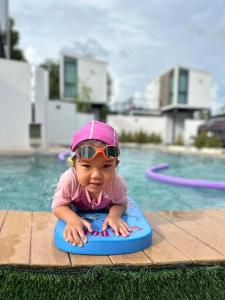 een klein meisje in een zwembad met een zonnebril op bij My Room by Sermsub in Aranyaprathet
