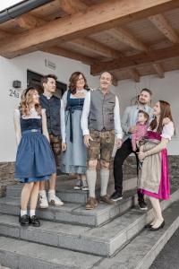 een groep mensen die op de trappen van een huis staan bij Hotel Alpina in Galtür