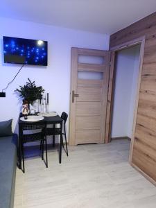 een eetkamer met een tafel en een houten deur bij Pokoje w Łomiankach Warszawa in Łomianki +2 foto's