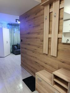 een houten muur in een woonkamer met een tafel bij Pokoje w Łomiankach Warszawa in Łomianki