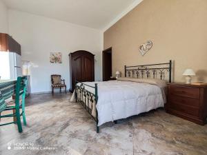 une chambre avec un lit, une commode et un réfrigérateur dans l'établissement Masseria Don Egidio, à Melendugno