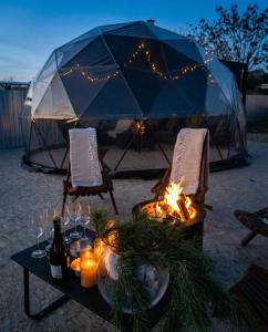 een tafel met kaarsen en een tent met lampen bij Era Maris in Odessa