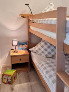 una camera con 2 letti a castello e un tavolo con una lampada di Ferienwohnungen Reutergut a Eibenstock