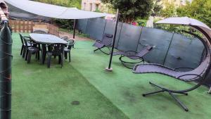 een speeltuin met een tafel en stoelen en een parasol bij Bright and cozy apartment in Sesto San Giovanni