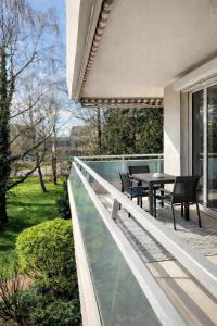 een terras met een tafel en stoelen op een balkon bij Séjour réussi à deux pas de Genève appartement 57m2 in Ferney-Voltaire