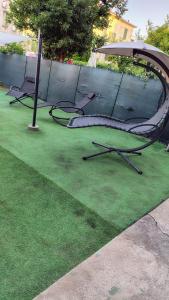 twee stoelen en een paraplu op een groen gazon bij Bright and cozy apartment in Sesto San Giovanni