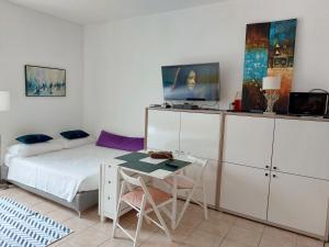 ein Schlafzimmer mit einem Bett, einem Tisch und einem Schreibtisch in der Unterkunft Lovely view in Nizza