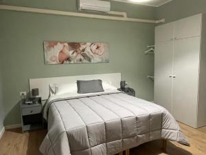een slaapkamer met een bed met een witte sprei en bloemen bij Il Mughetto in Lecco