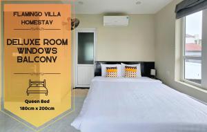 een slaapkamer met een bed met een geel bord aan de muur bij Flamingo Homestay - Spacious Room with Comfortable Spring Mattress - 200m from Hoi An Ancient Town & Night Market in Hội An +74 foto's