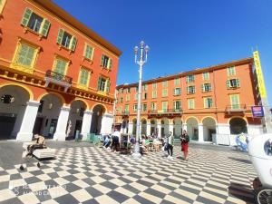 Eine Gruppe von Menschen sitzt in einem Innenhof mit Gebäuden in der Unterkunft Lovely view in Nizza
