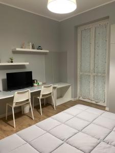 a white room with a desk and a table and chairs at Il Mughetto in Lecco
