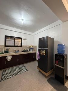 eine Küche mit einem schwarzen Kühlschrank und einer Spüle in der Unterkunft Soglad Transient House in San Juan