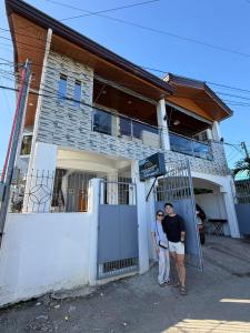 Ein Mann und eine Frau stehen vor einem Haus in der Unterkunft Soglad Transient House in San Juan