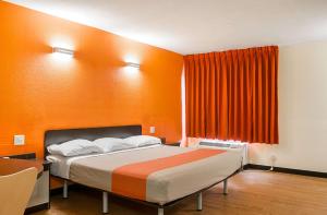 a bedroom with a bed with an orange wall at Motel 6-New Orleans, LA - Near Downtown in New Orleans
