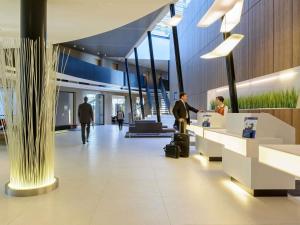 een lobby van een luchthaven met mensen die bij een balie wachten bij Novotel Hannover in Hannover
