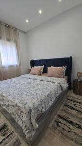 een slaapkamer met een groot bed met een blauw hoofdeinde bij Le luxe MENZAH5 in Ariana