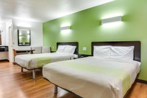 two beds in a room with green walls at Motel 6-Longview, TX - North in Longview +37 photos