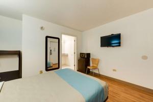 ein Schlafzimmer mit einem Bett und einem Spiegel sowie einem TV in der Unterkunft Motel 6-Kingston, TN in Kingston
