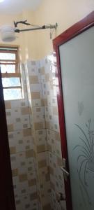 a bathroom with a shower with a glass door at Siwarani Cozy Two bedroom,Kamakis Eastern Bypass Ruiru in Ruiru +14 photos