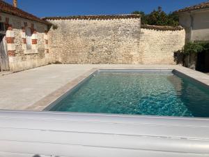 einen Pool im Innenhof eines Gebäudes in der Unterkunft Le Brissonneau in Saint-Saturnin