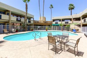 a patio with a table and chairs next to a pool at Motel 6 Glendale Phoenix in Glendale