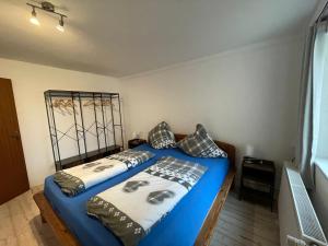 2 letti in una camera con lenzuola e cuscini blu di FeWo Renken a Trassenheide