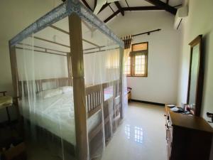a bedroom with a canopy bed in a room at VILLA Sea La THALPE in Talpe