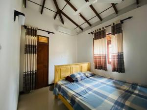a bedroom with a bed with a blue plaid at VILLA Sea La THALPE in Talpe