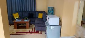 a living room with a blue couch and a table at Siwarani Cozy Two bedroom,Kamakis Eastern Bypass Ruiru in Ruiru