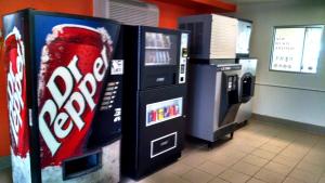 uma máquina de refrigerante de cocacola e um frigorífico de cocacola em Motel 6-Ely, NV em Ely