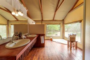 ein Badezimmer mit zwei Waschbecken und einem großen Fenster in der Unterkunft Lion Tree Top Lodge in Guernsey Nature Reserve