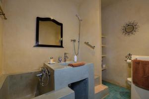 un bagno con un lavandino, una vasca e uno specchio di Riad Salmiya Dune a Essaouira Altre 75 foto