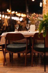 a table with wine glasses and a vase with flowers on it at Hotel Nordik in Motički Gaj