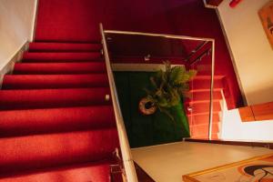 un escalier rouge avec une plante en pot accrochée au mur dans l'établissement Glands Ndera f04, à Kigali