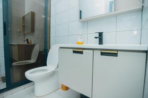 une salle de bains blanche avec toilettes et lavabo dans l'établissement Glands Ndera f04, à Kigali